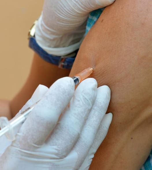 Injection being administered to a person's arm.