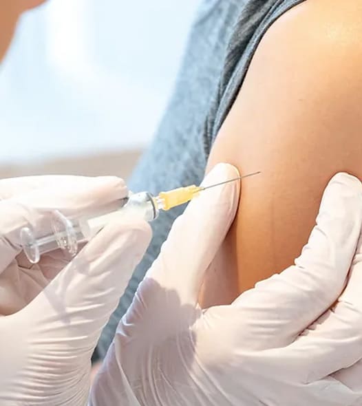 Vaccination administered with syringe in arm.