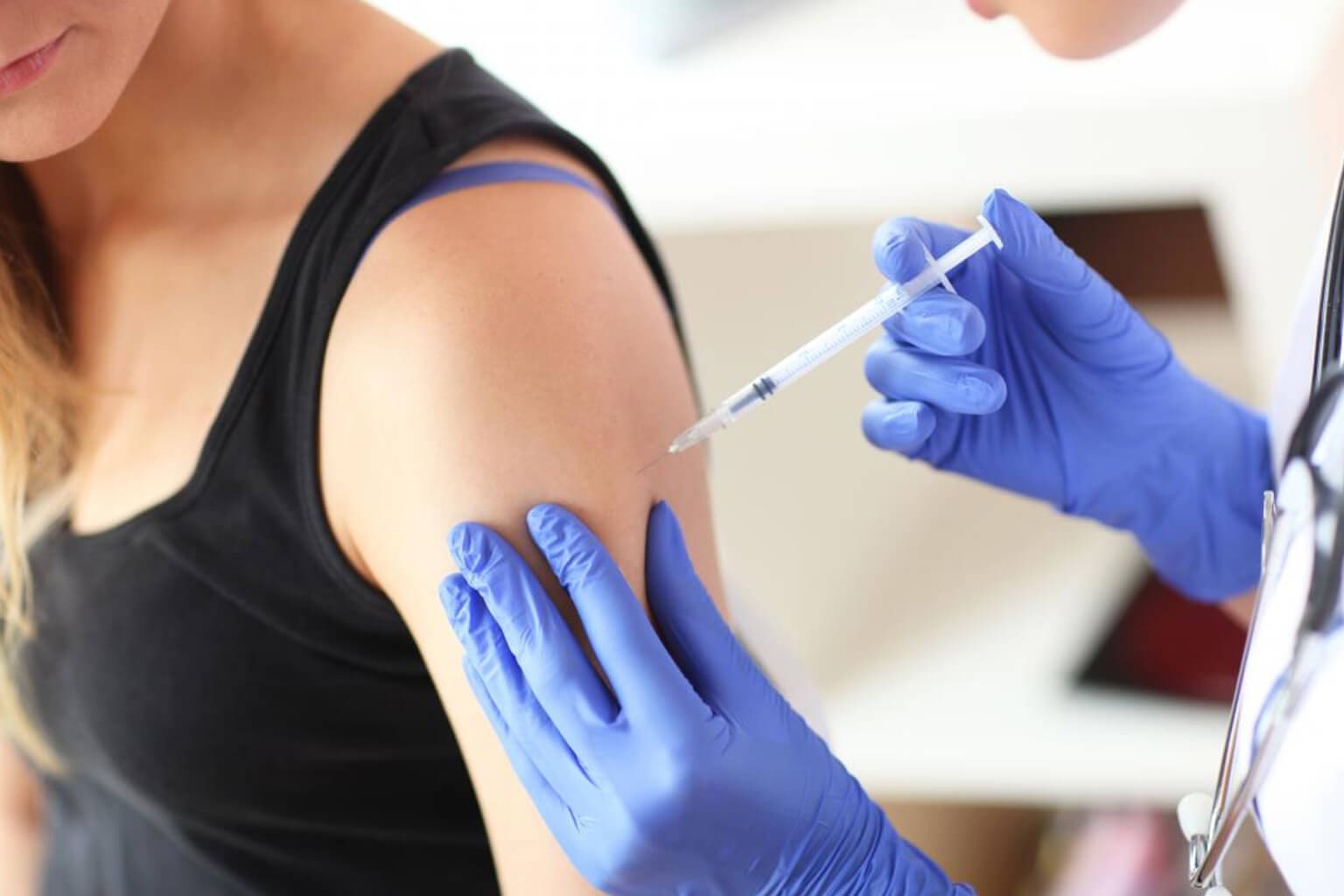 Person receiving a vaccine injection in arm.