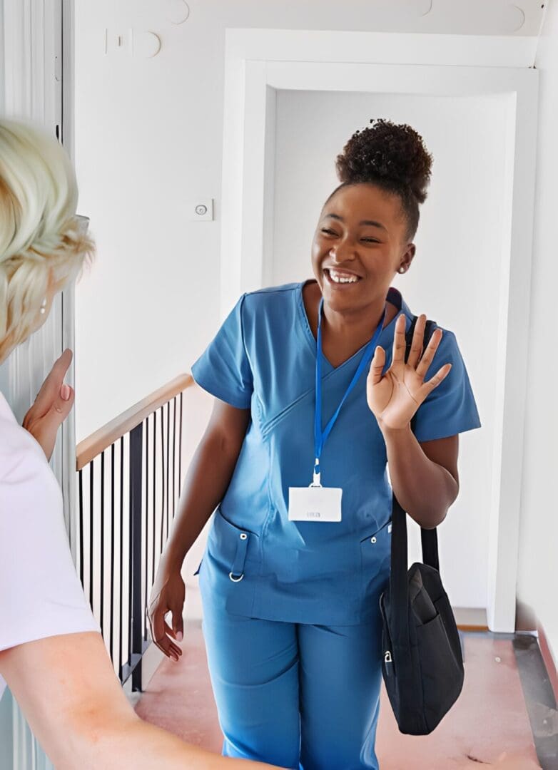 Smiling nurse greeting someone at doorway.